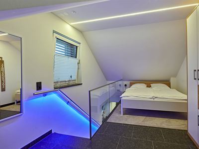 Schlafbereich im Obergeschoss mit Doppelbett unter der Dachschräge